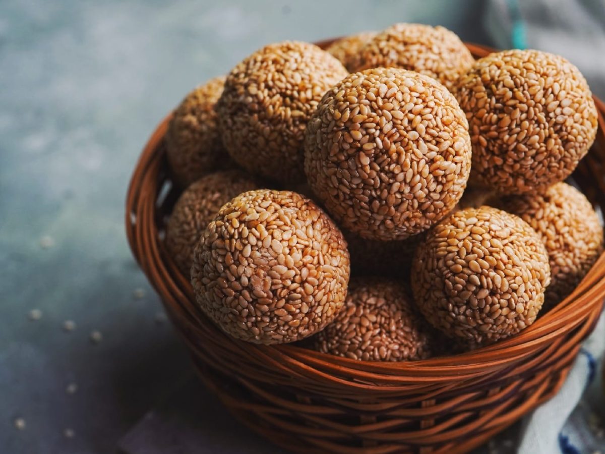 Eine braune Schale mit den Laddu-Kugeln auf grauem Untergrund.