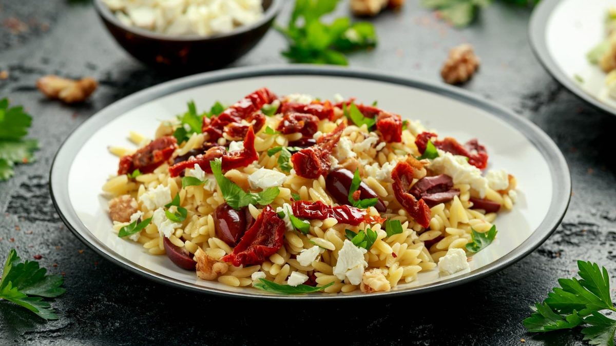 Orzo-Tomatensalat mit Feta und Oetersilie auf einem Teller