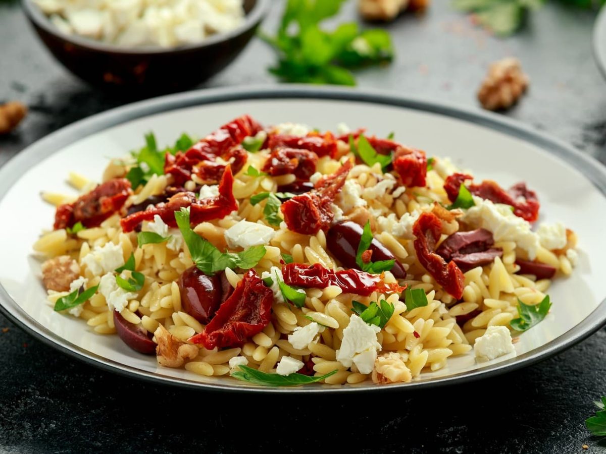 Orzo-Tomatensalat mit Feta und Oetersilie auf einem Teller