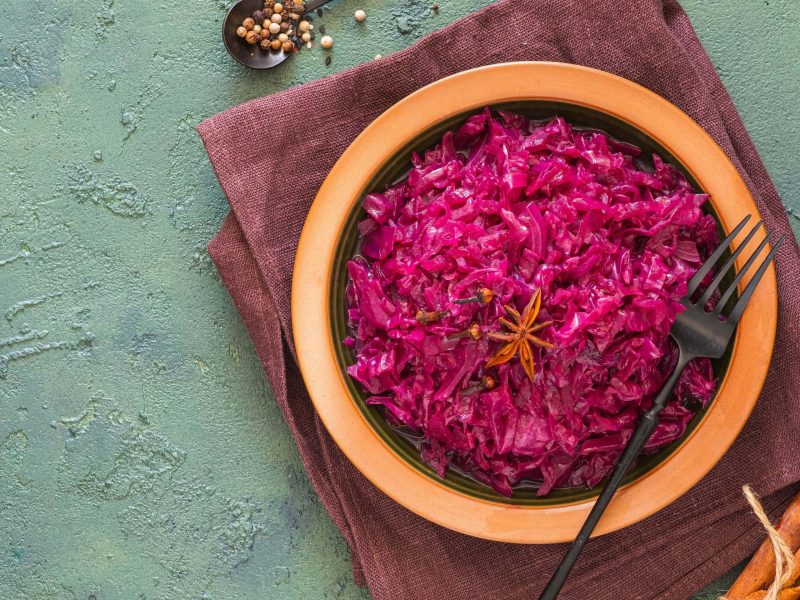 Ein Topf mit Rotkohl auf einem türkisfarbenen Untergrund.