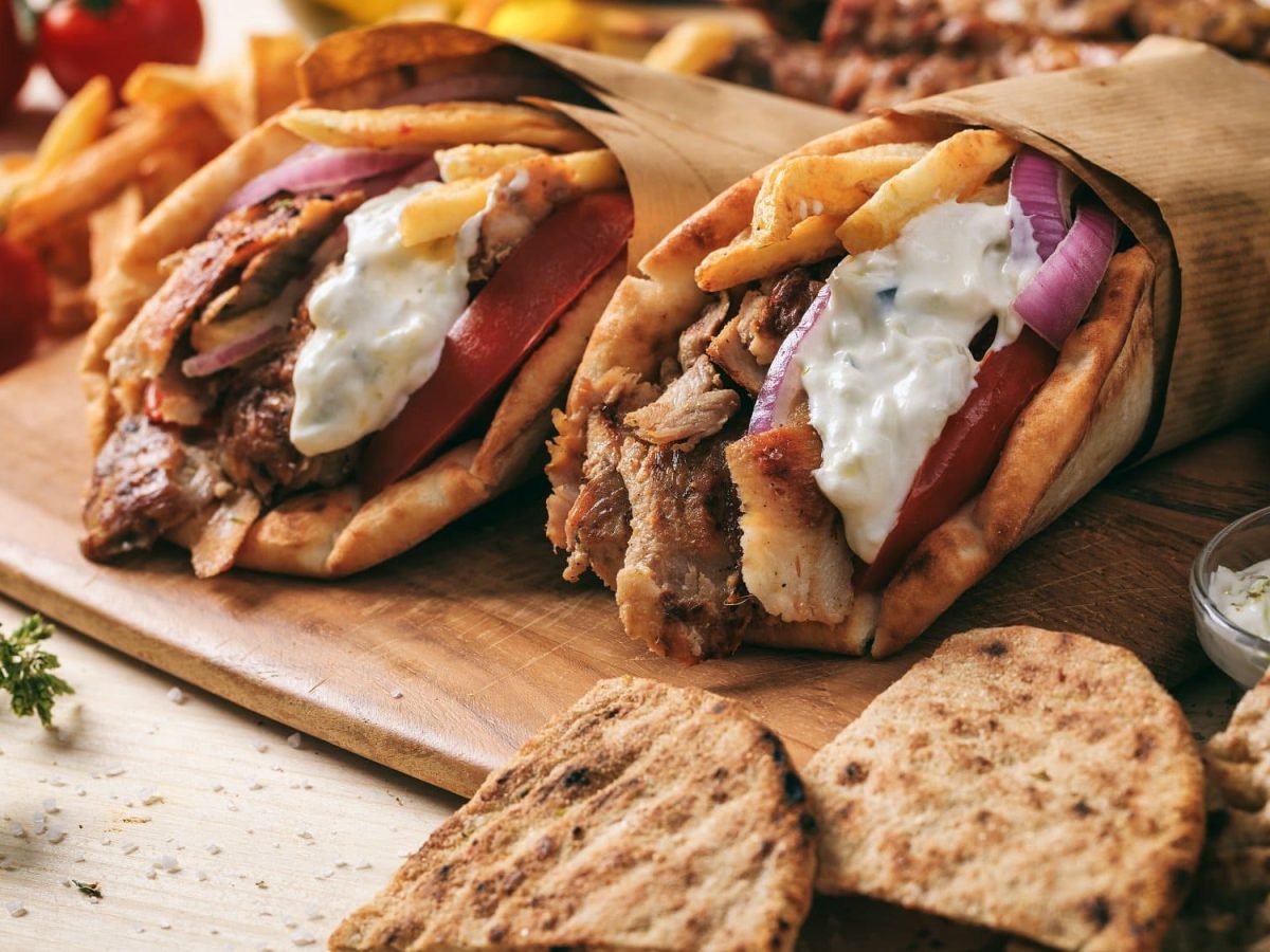 Zwei Mal veganes Gyros im Pitabrot mit Tzatziki, Pommes, roten Zwiebeln und Tomaten.