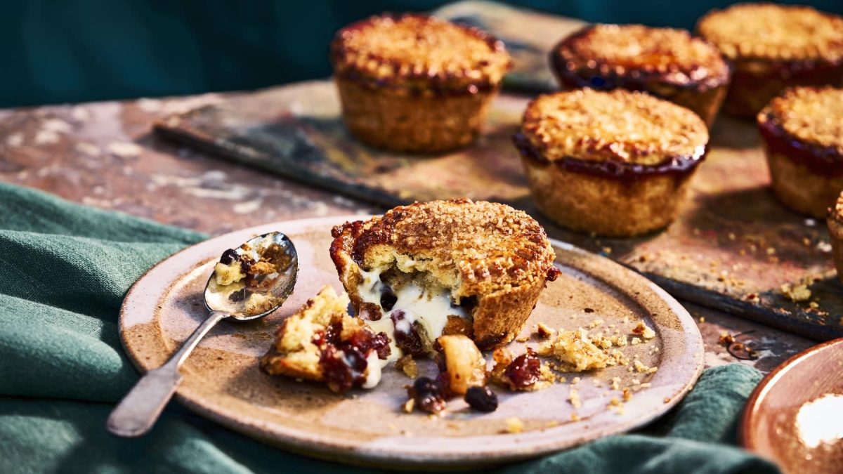 Mince Pies mit Rumrosinen und Custard-Füllung, angebrochen auf einem Tonteller serviert.