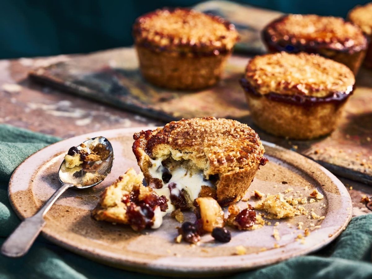 Mince Pies mit Rumrosinen und Custard-Füllung, angebrochen auf einem Tonteller serviert.