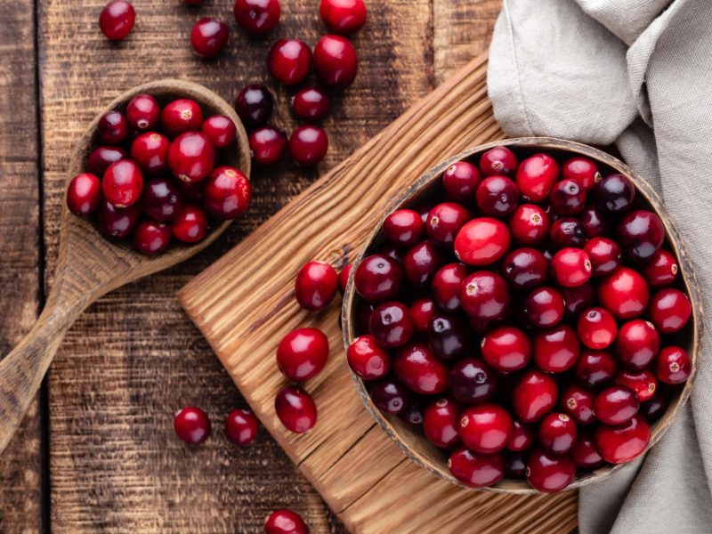 Cranberries auf einem dunklen Holzuntergrund.