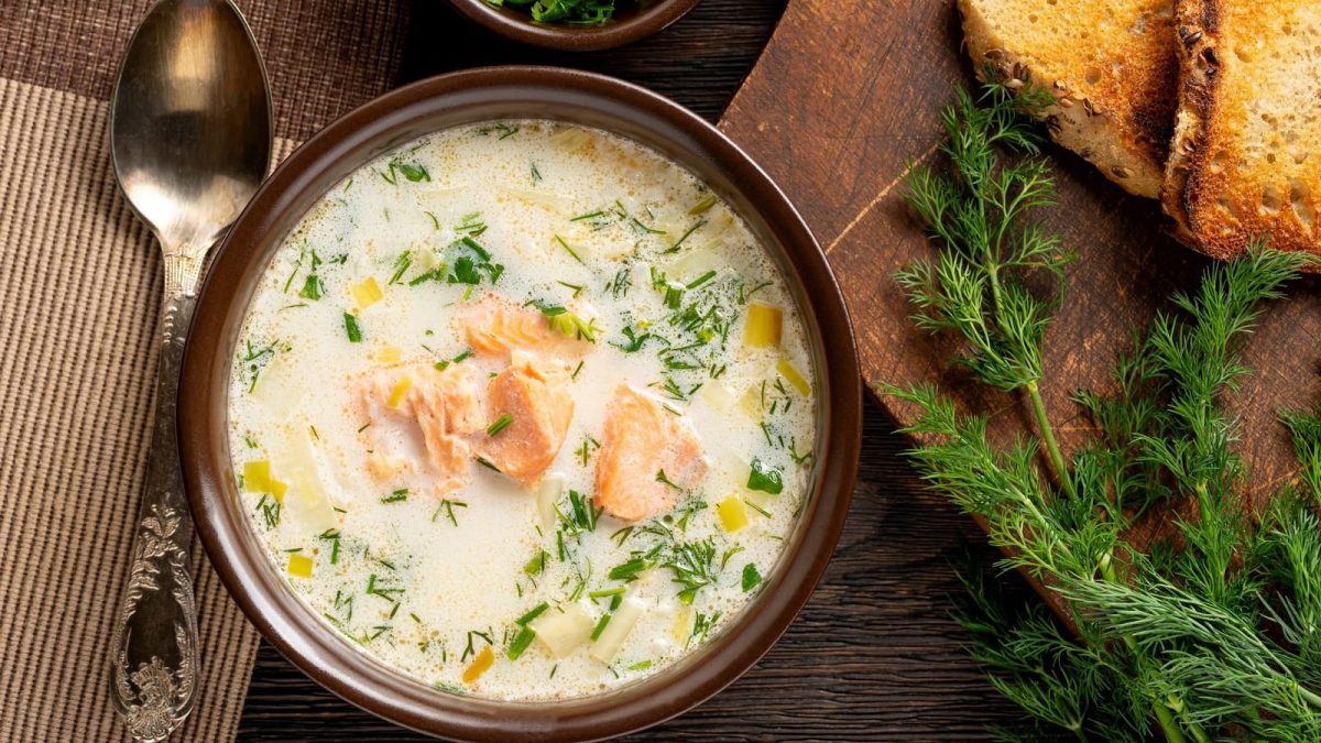 Eine runde Schüssel mit Lachs-Lauchcremesuppe mit Dill.