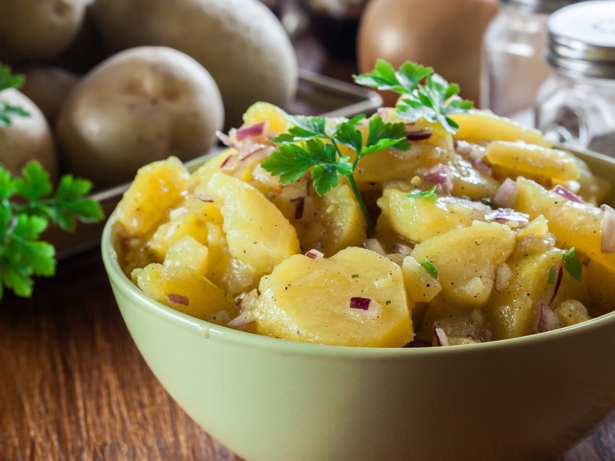 Eine Schüssel französischer Kartoffelsalat mit roten Zwiebeln und Petersilie.