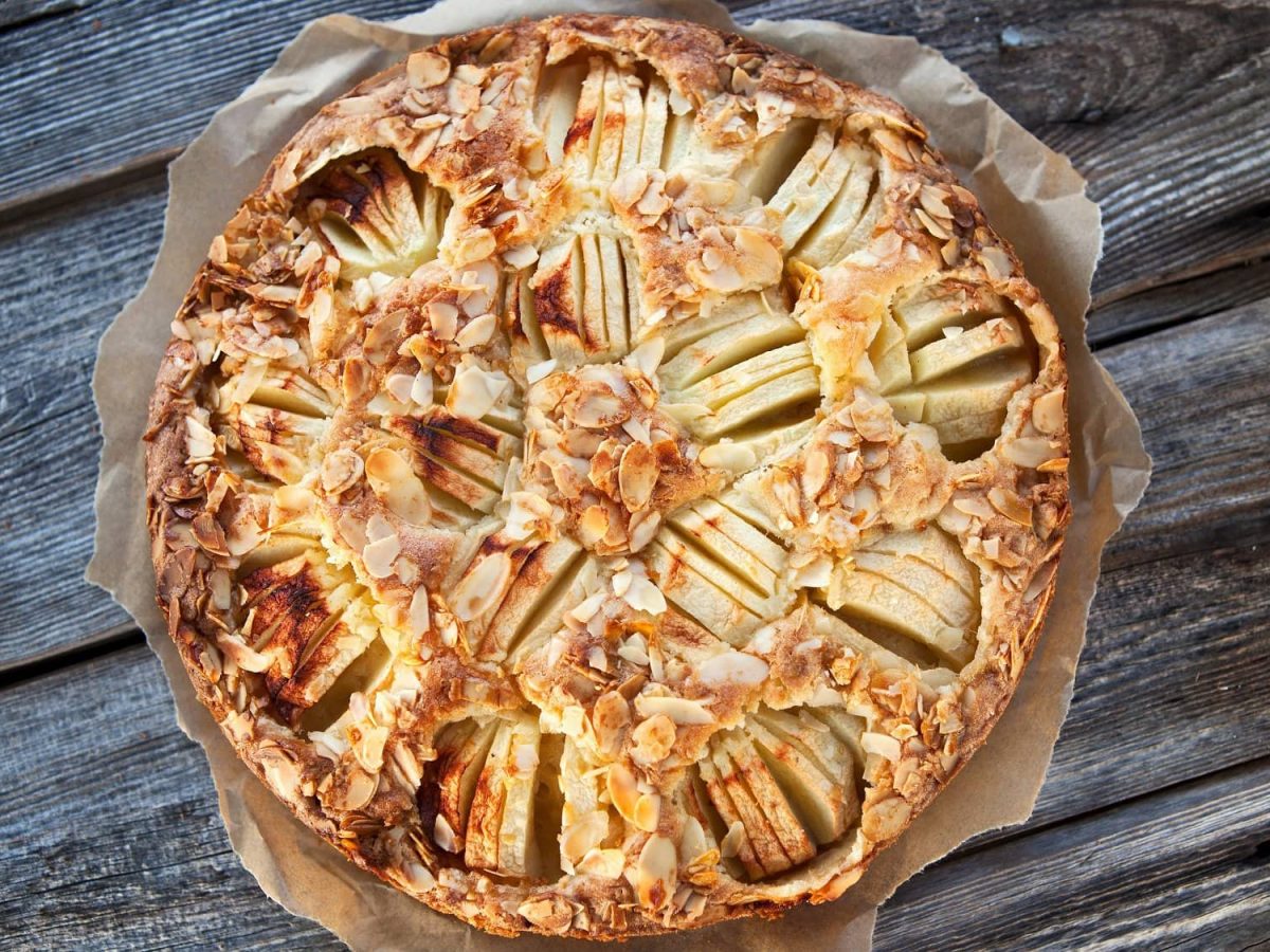 Ein veganer versunkener Apfelkuchen mit Zimtäpfeln und Mandeln in der Draufsicht.