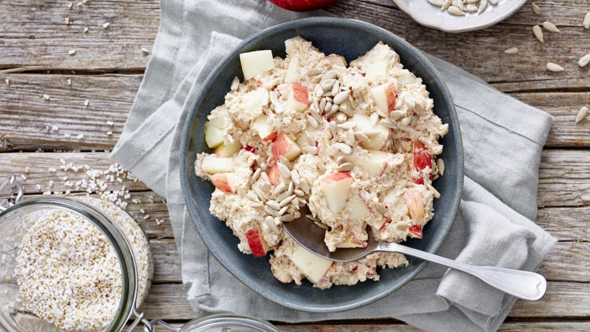 In einer Schüssel ist ein Joghurt mit Amaranth und Apfel angerichtet.