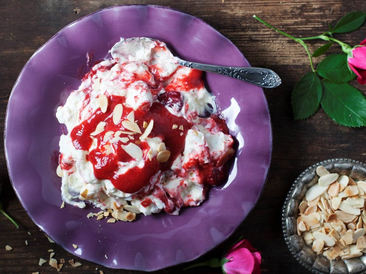 Erdbeer-Baiser-Dessert auf lila Teller.