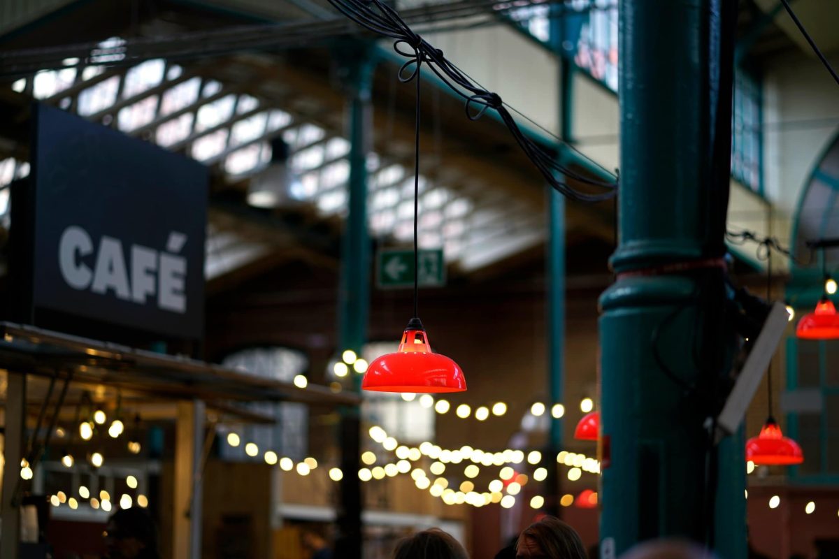 Christmas Klimbim: Eine Markthalle mit Lichterketten und einem "Café"-Schild.