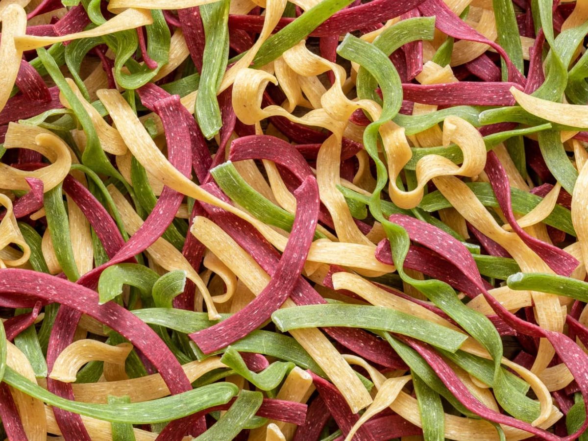 Bunte Pasta selbst machen - viele Tagliatelle in rot, gelb und grün.