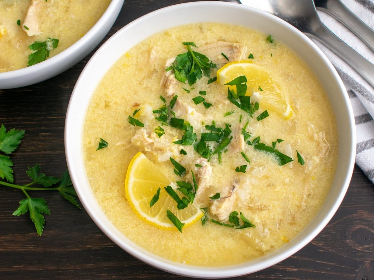 Eine Schüssel mit Avgolemono auf einem Holztisch.