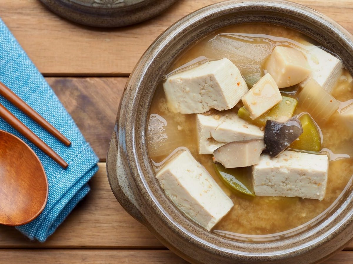 Eine Schüssel mit Doenjang Jjigae auf einem Holztisch.