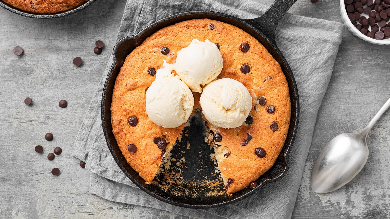 Riesen-Cookie aus der Pfanne auf einem grauen Geschirrtuch.