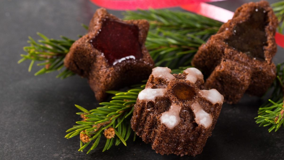 Drei Mandelküchlein mit Weihnachtsgewürzen in Form von Sternen und Tannenbäumen.