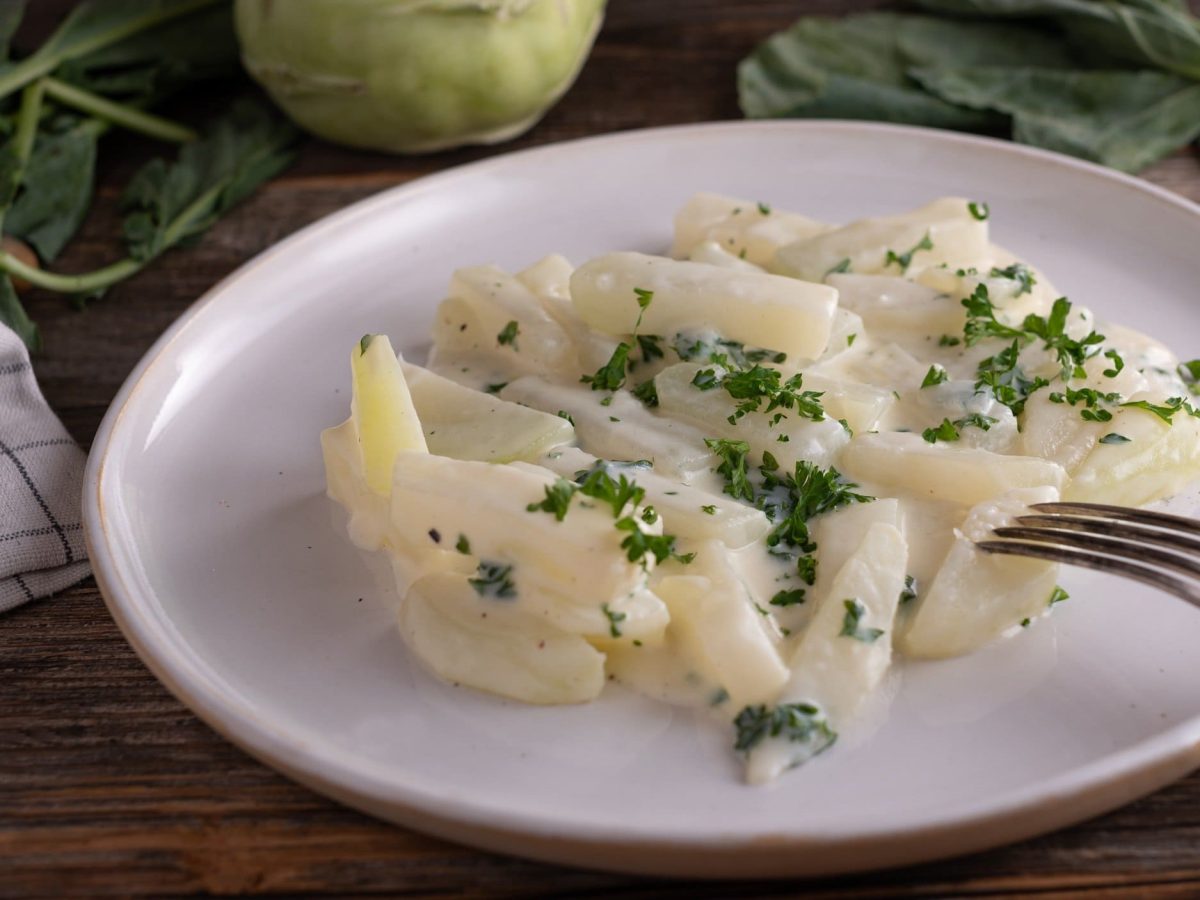 Ein Teller veganer Rahmkohlrabi mit Petersilie bestreut.