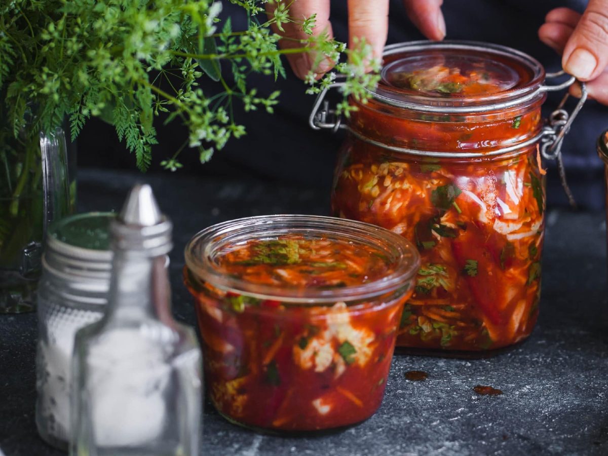 Zwei Kimchi-Gläser auf einem dunklen Untergrund.