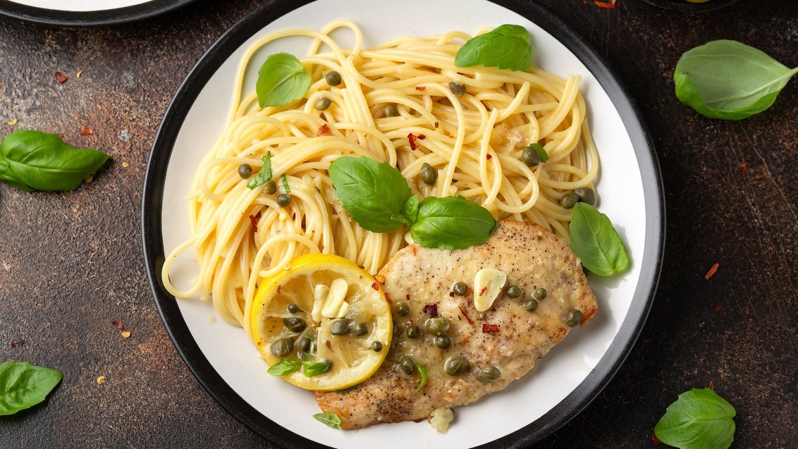 Ein Teller mit Chicken Piccata auf einem Holztisch.