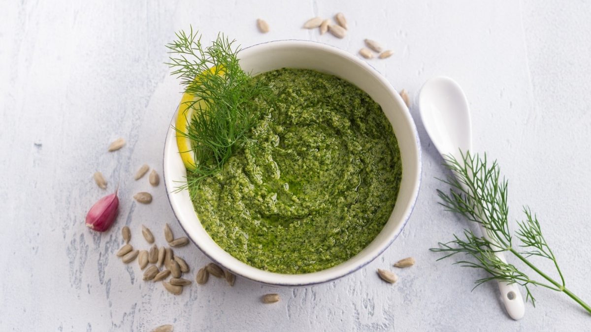 Eine Schale mit Dill-Pesto auf einem weißen Tisch.