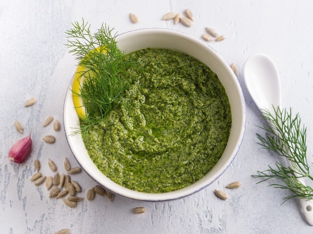 Eine Schale mit Dill-Pesto auf einem weißen Tisch.