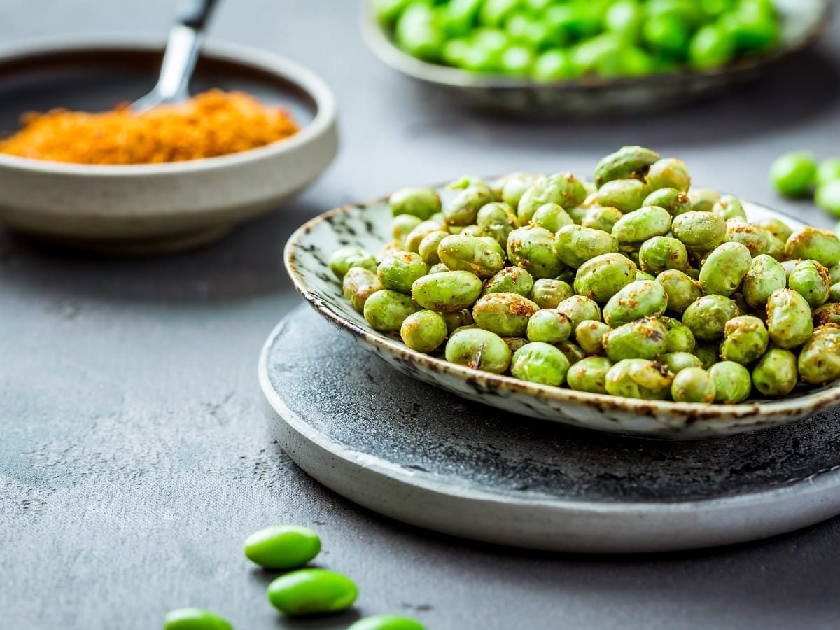 Eine Schüssel mit Roasted Edamame auf einem Tablett.