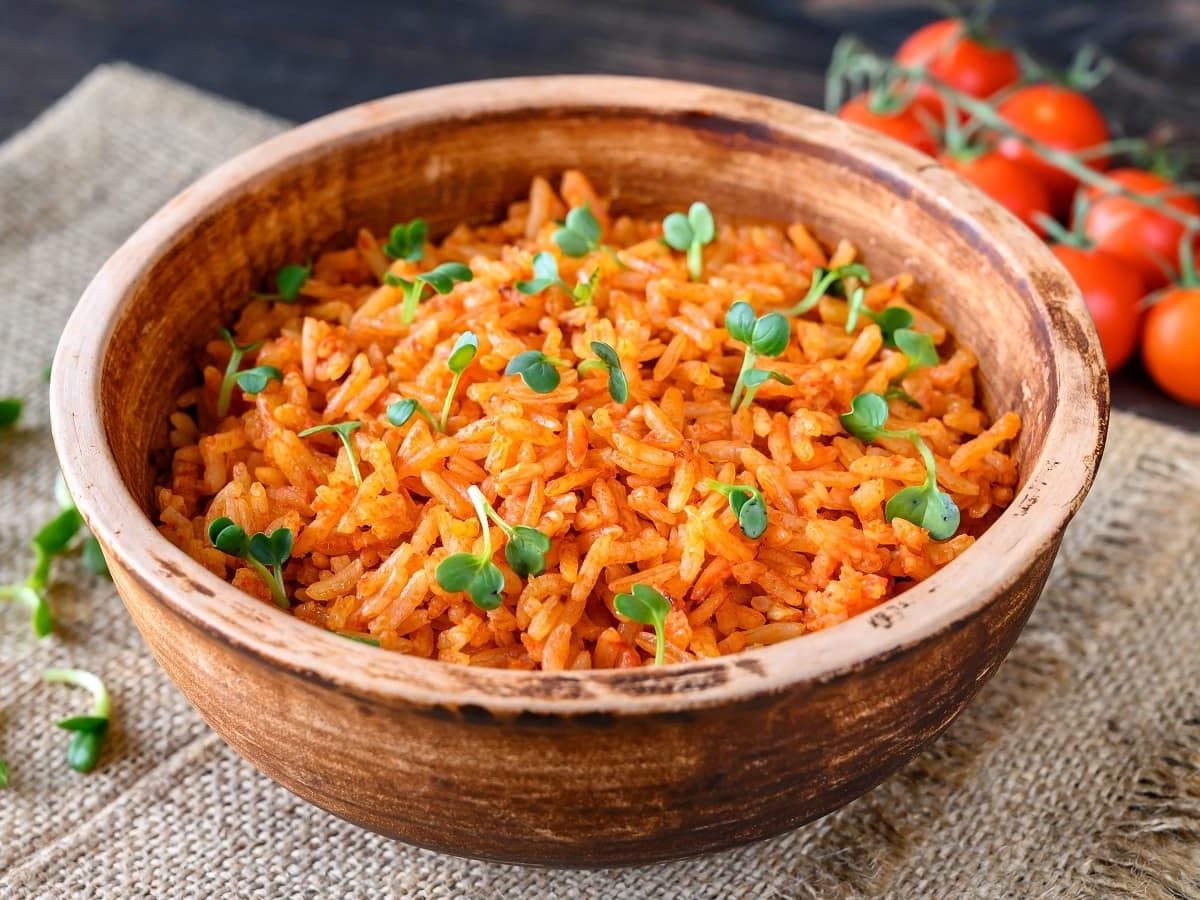 Eine Keramikschüssel mit Arroz rojo auf einem Leinentuch.