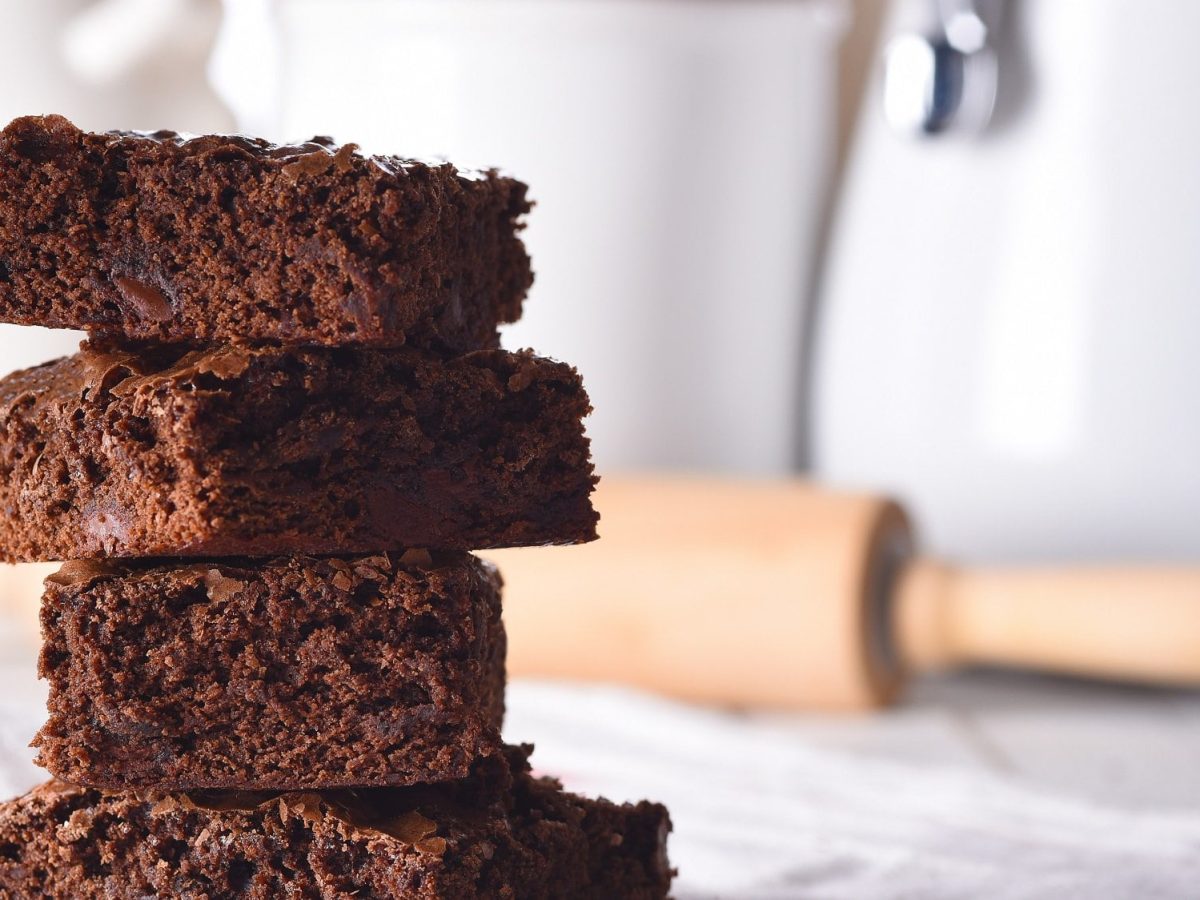 Ein Stapel Oreo-Brownies, dahinter unscharf ein Nudelholz.