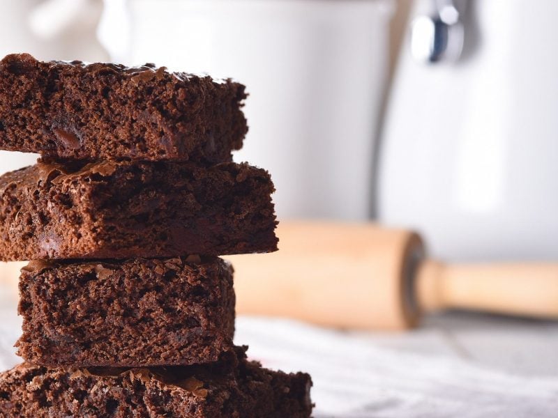 Ein Stapel Oreo-Brownies, dahinter unscharf ein Nudelholz.