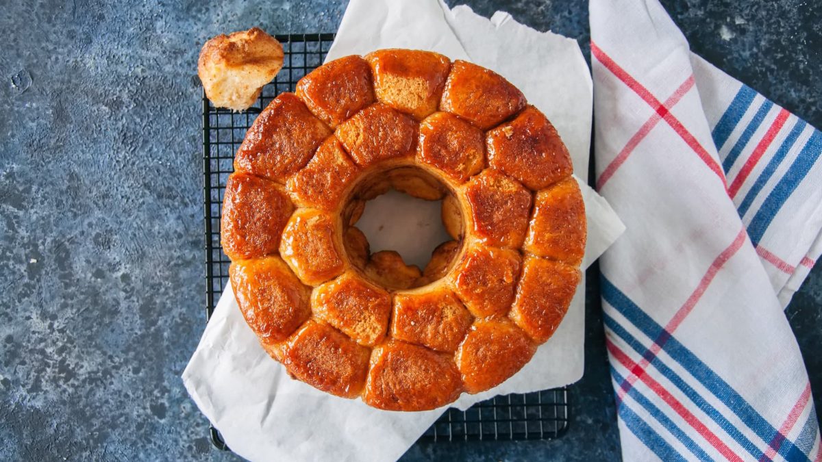 Ein Veganes Monkey Bread mit Zimt in der Draufsicht, daneben ein Geschirrtuch.