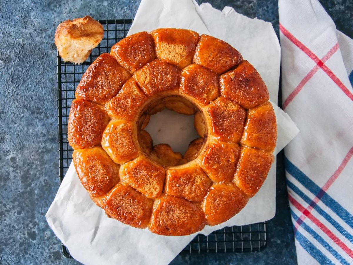 Ein Veganes Monkey Bread mit Zimt in der Draufsicht, daneben ein Geschirrtuch.