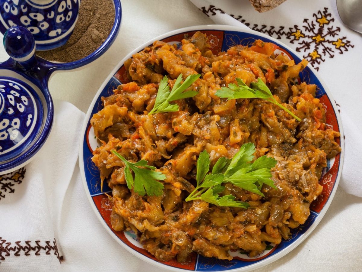 Zaalouk warmer marokkanischer Auberginensalat in Schale auf Tischtuch. Im Bild traditionelles Geschirr. Draufsicht.