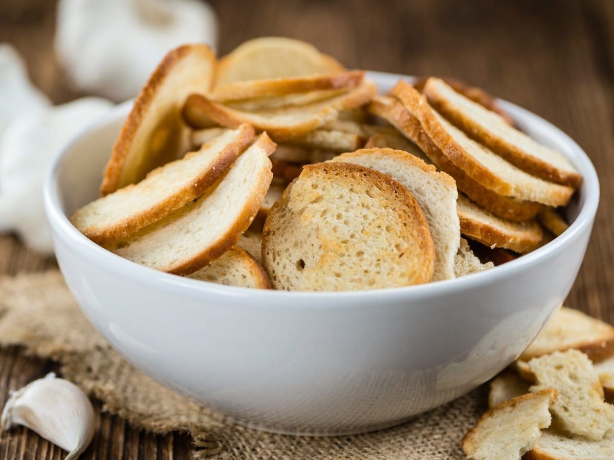 Eine Schale Brezel-Chips, daneben Knoblauch.