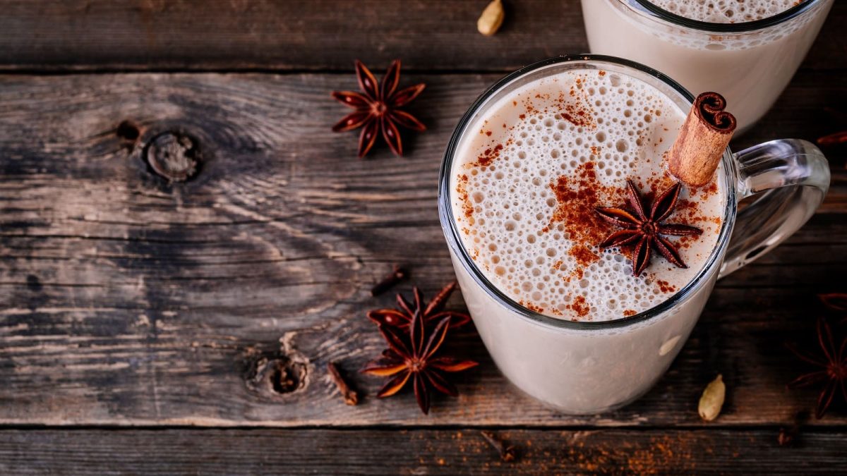 Eine Tasse mit Apfel-Chai-Latte auf einem Holztisch.