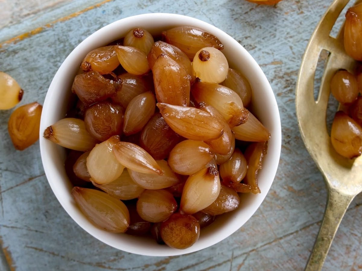 Eine Schüssel mit Balsamico-Zwiebeln auf einem hellblauen Tuch.