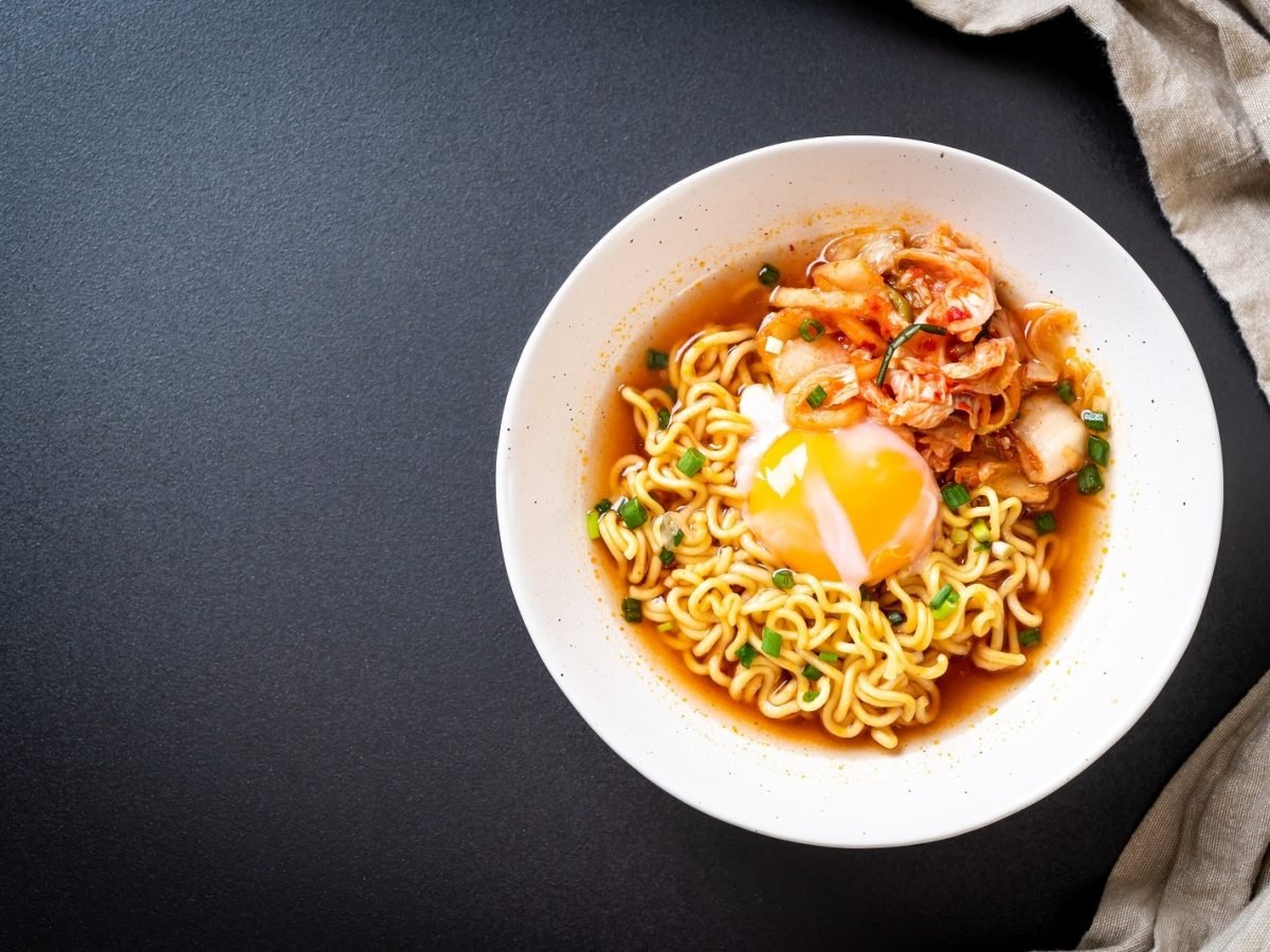 Ein Tisch mit Instant Ramen neben einem grauen Tuch.