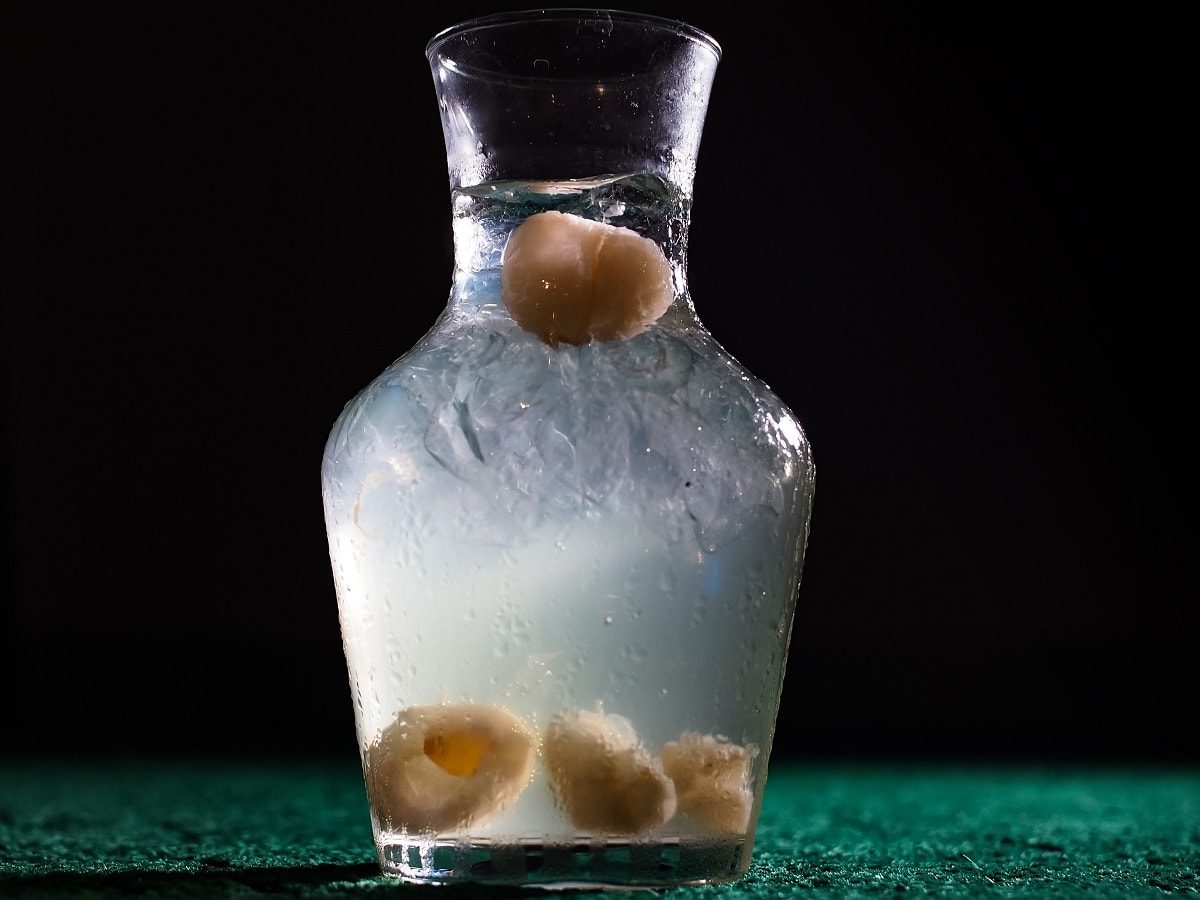 Eine Flasche mit Litschi-Sirup auf einem dunklen Hintergrund.