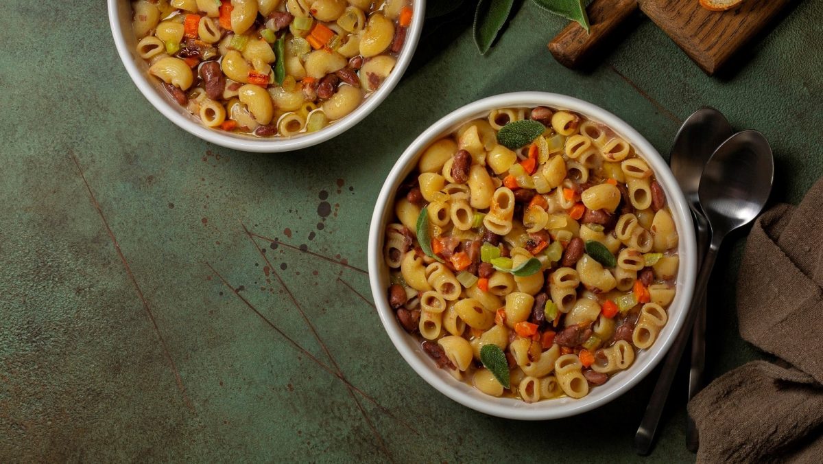 Zwei Schüsseln mit veganer Pasta e fagioli auf einem grauen Tisch.