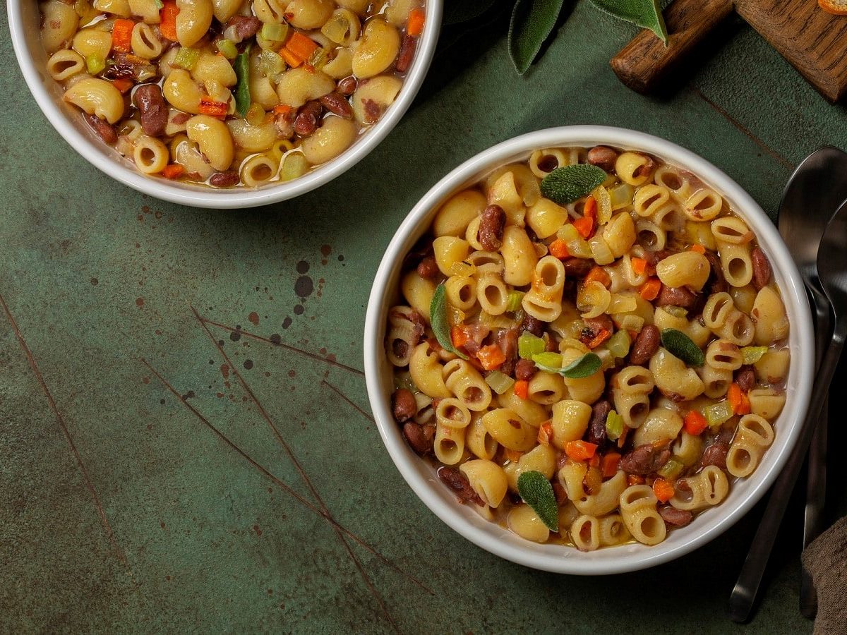 Zwei Schüsseln mit veganer Pasta e fagioli auf einem grauen Tisch.