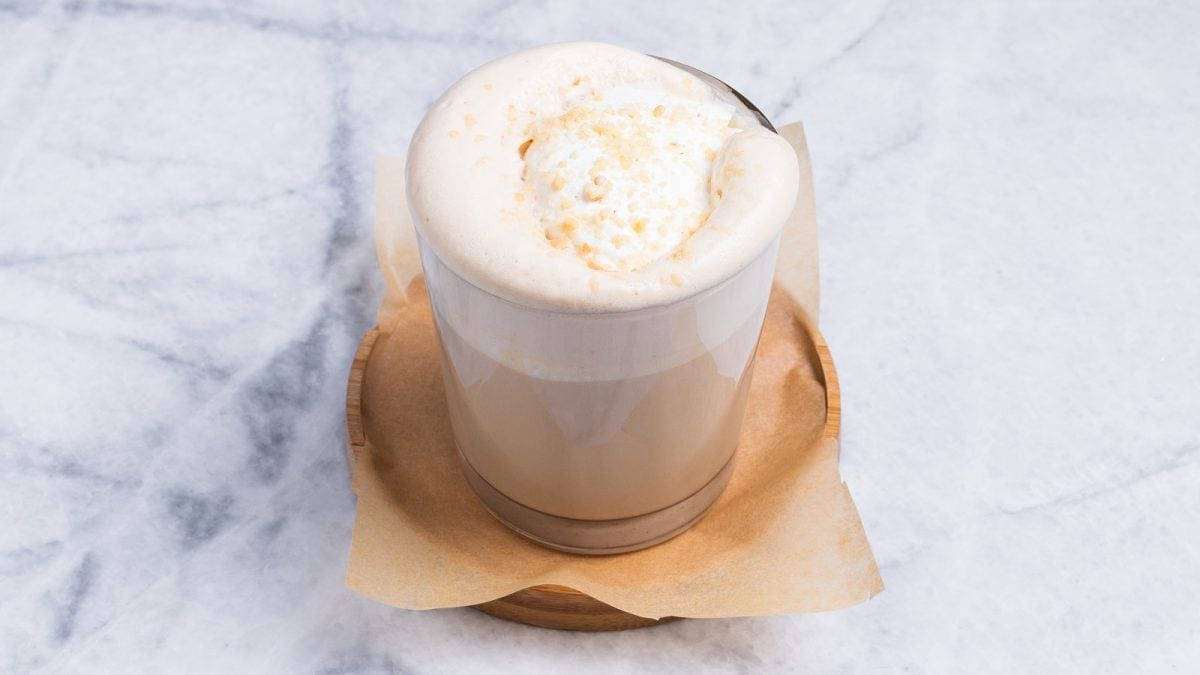 Ein Glas mit White Chocolate Latte auf einer Untertasse