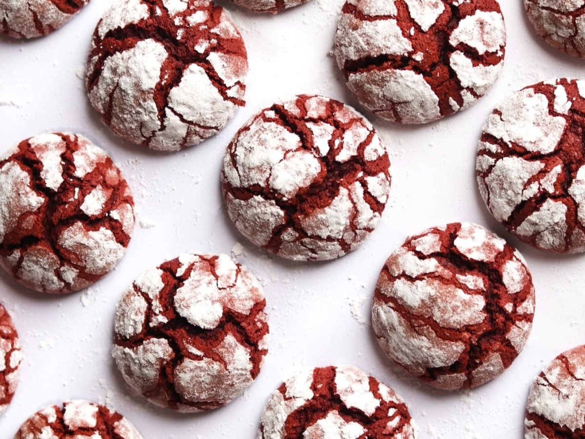 Mehrere Red Velvet Crinkle Cookies in der Draufsicht auf weißem Hintergrund.