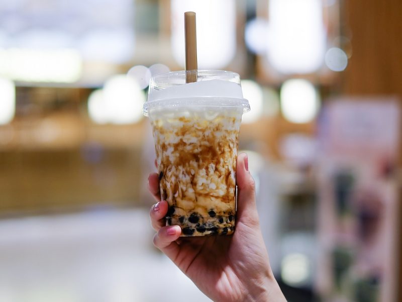 Hand einer Frau, die Bubble Tea festhält.