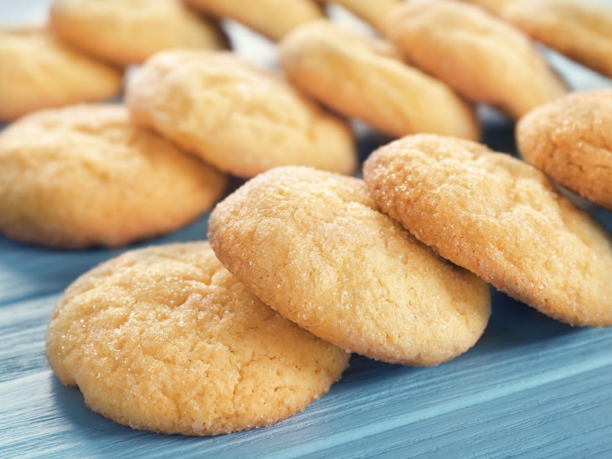 Champagner-Vanille-Cookies auf blauem Untergrund.