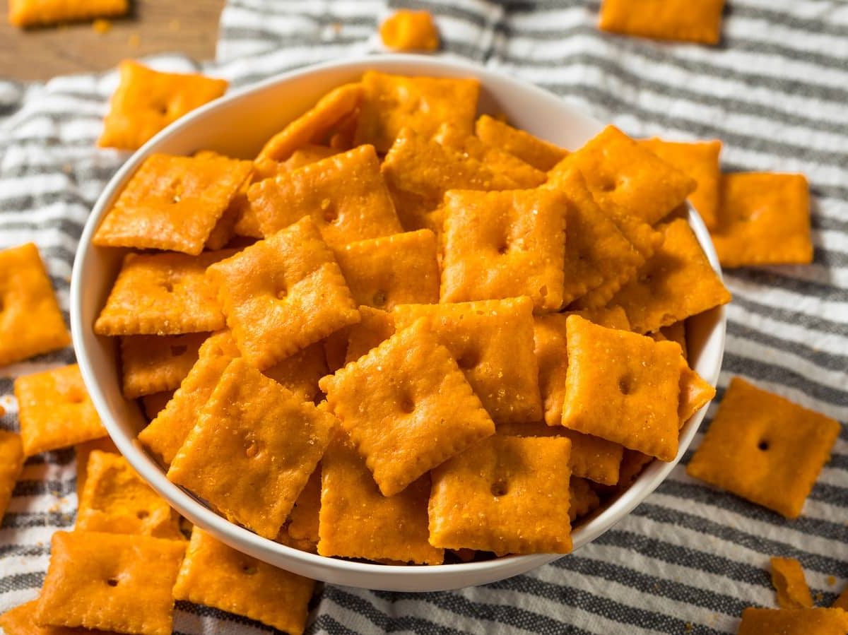 Eine Schüssel mit Cheddar Cracker auf einem Geschirrtuch.