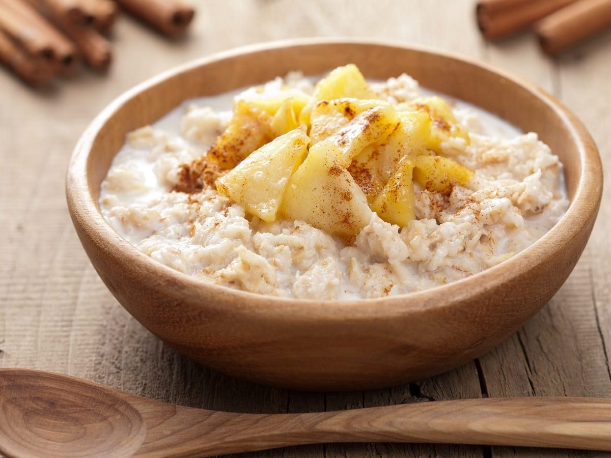 Eine braune Schüssel mit Chai-Porridge auf einem Holztisch.