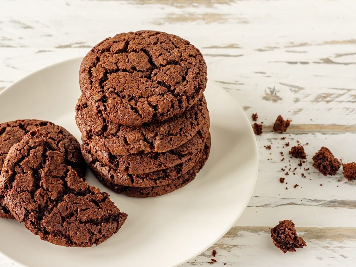 Ein weißer Teller mit einem Stapel Espresso Cookies.