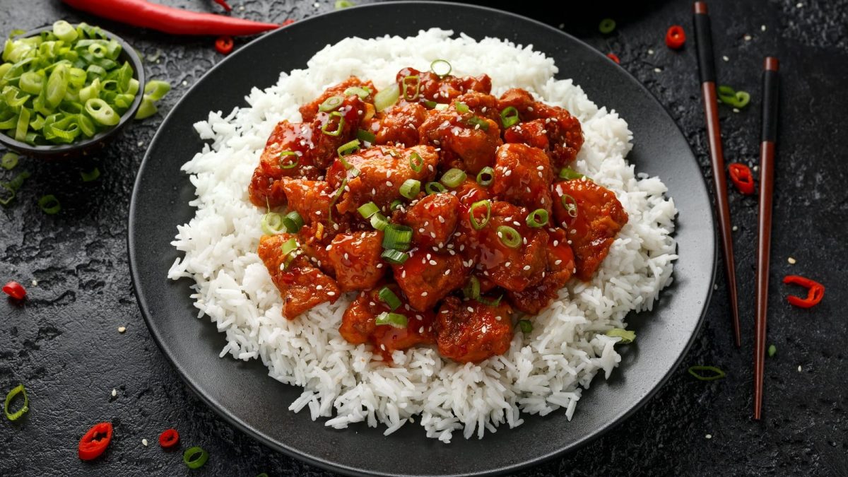 Ein schwarzer Teller mit General Tso's Chicken.