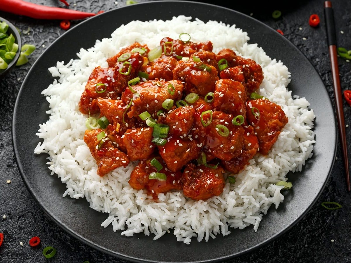 Ein schwarzer Teller mit General Tso's Chicken.