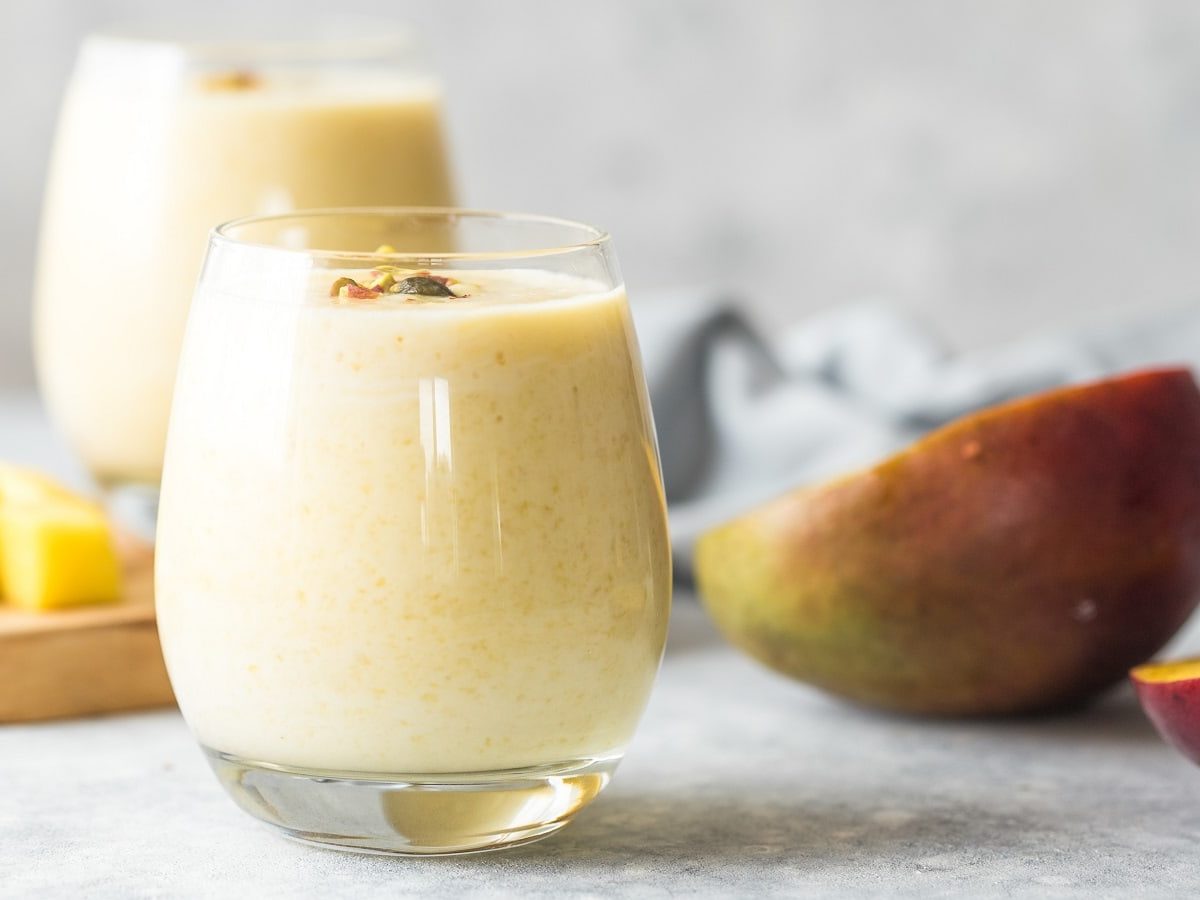 Ein Glas mit einem Kokos-Mango-Smoothie.