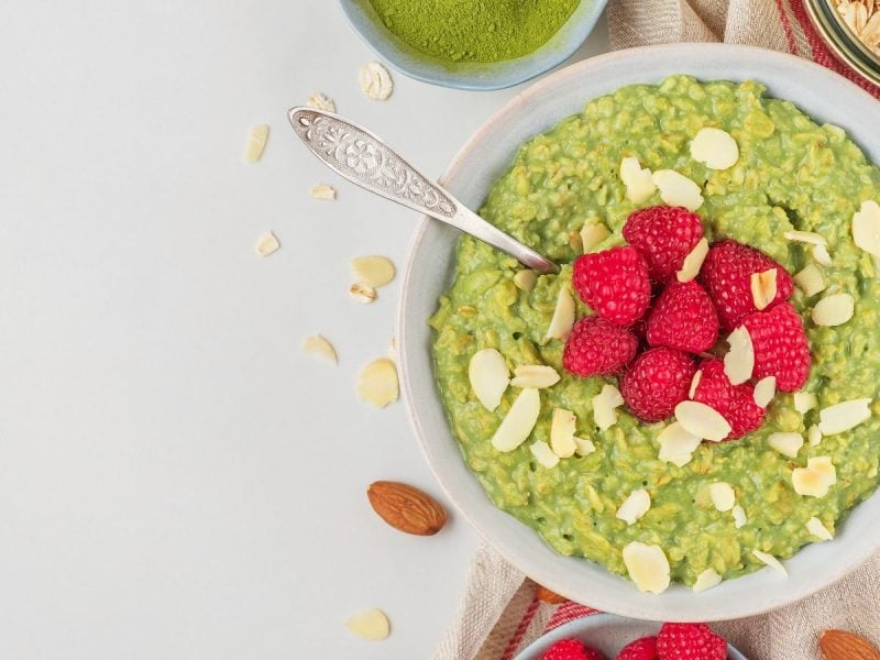 Eine Schüssel mit Matcha-Porridge auf einem hellgrauen Tisch.