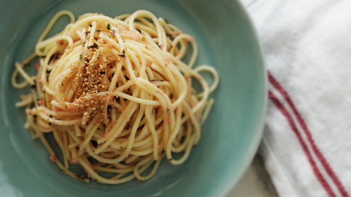 Ein blauer Teller mit Miso Butter Pasta auf einem Geschirrtuch.